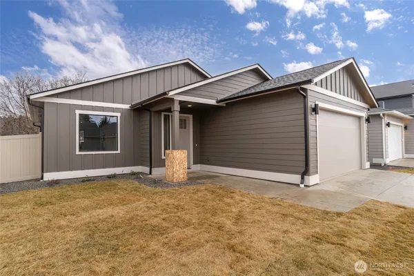 a view of house with yard and garage