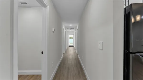 a view of wooden floor and a chandelier fan in a room