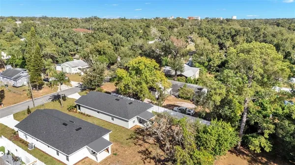 an aerial view of residential houses with outdoor space and trees