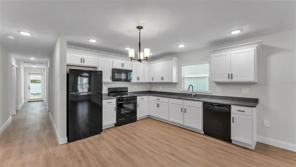 a kitchen with granite countertop white cabinets and a sink