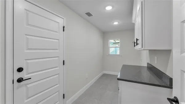 a kitchen with white cabinets and a wooden floor