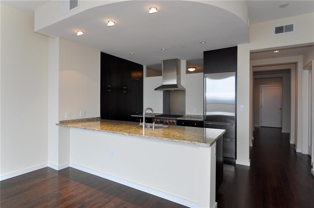 3325 Piedmont Road Northeast, Unit 1604 Atlanta, GA 30305 - Photo 1 of 1 a kitchen with granite countertop a sink and a stove top oven