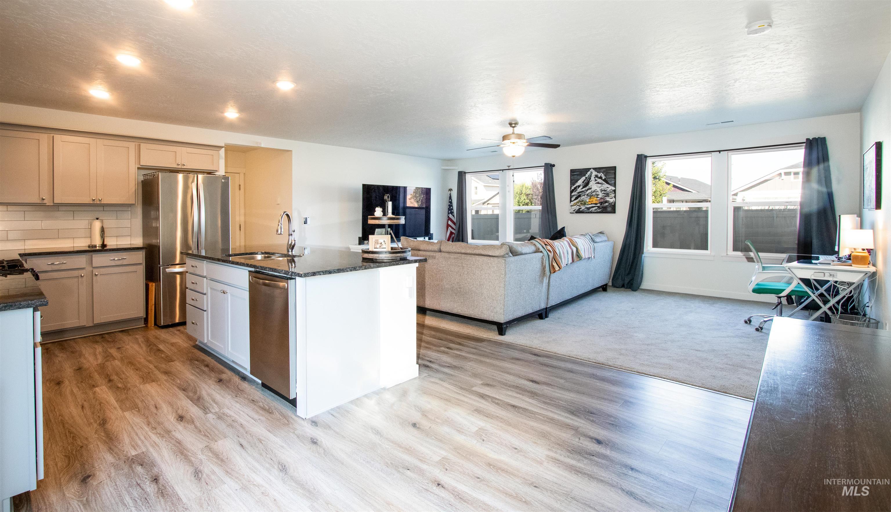 7698 South Seabreeze Way Boise, ID 83709 - Photo 16 of 16 Kitchen with stainless steel appliances, an office area, dark stone countertops, open floor plan, and an island with sink