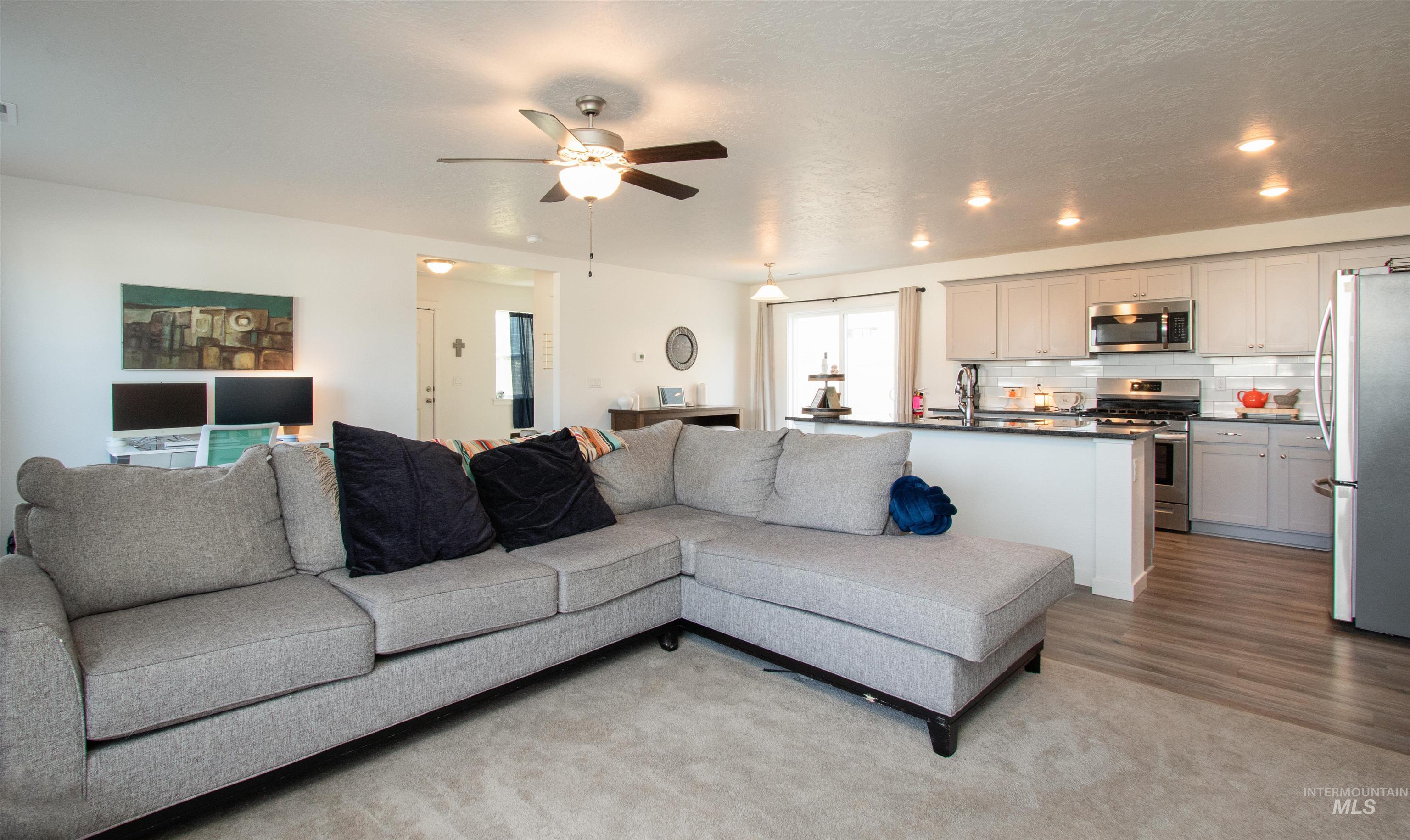 7698 South Seabreeze Way Boise, ID 83709 - Photo 6 of 16 Living room with a ceiling fan, a textured ceiling, and light wood-style flooring