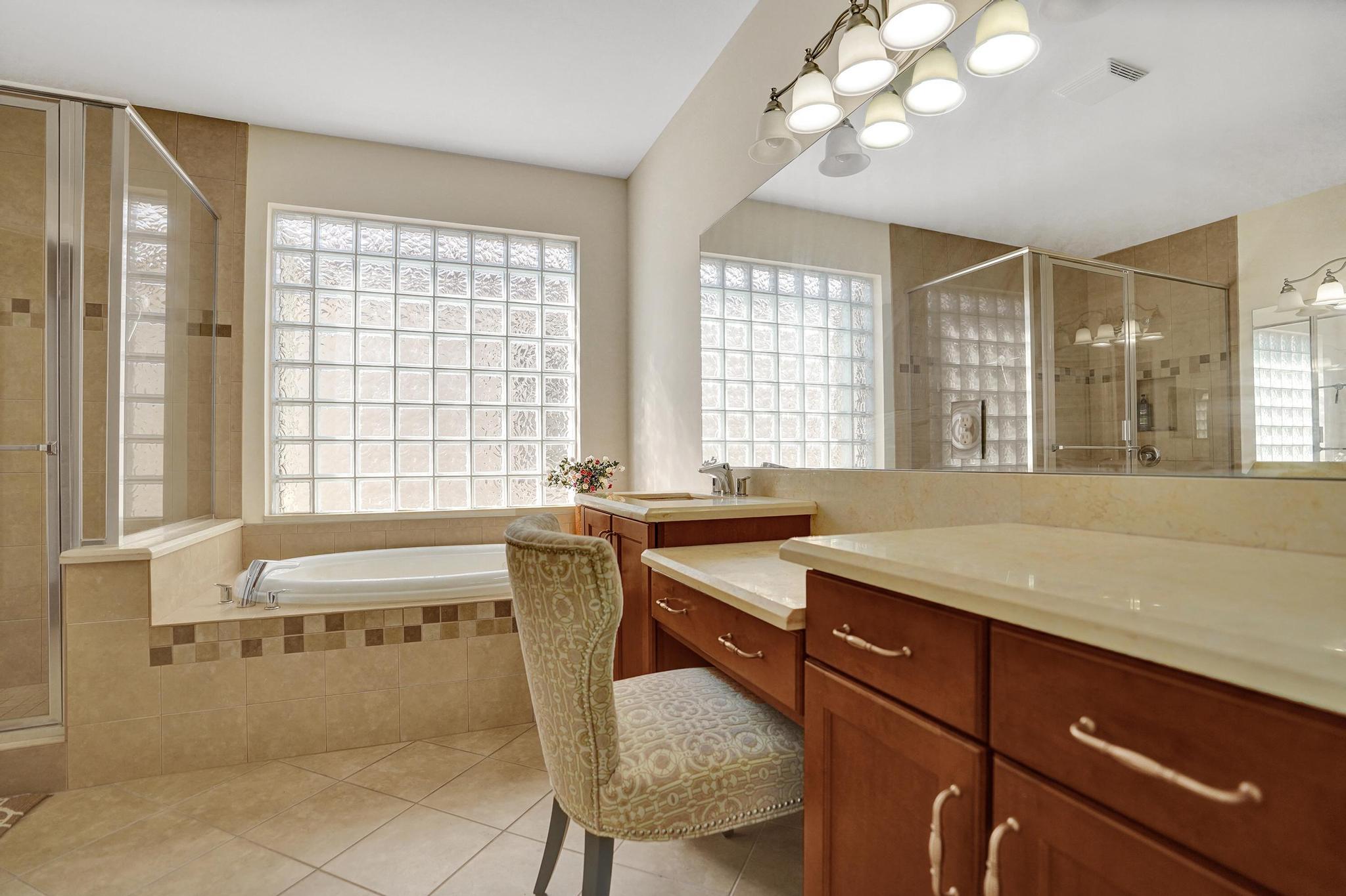16610 Gateway Bridge Drive Delray Beach, FL 33446 - Photo 13 of 67 a bathroom with a granite countertop sink a large mirror and a bathtub next to a window