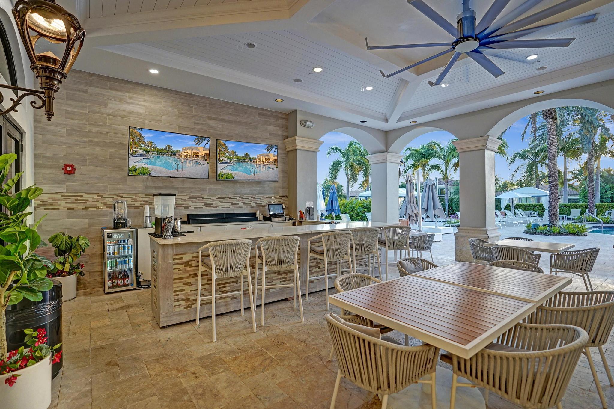16610 Gateway Bridge Drive Delray Beach, FL 33446 - Photo 50 of 67 a view of a dining room with furniture large windows and a chandelier
