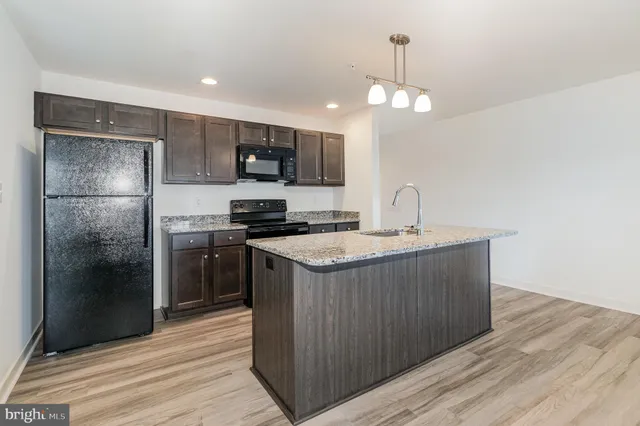 a kitchen with a sink stainless steel appliances a refrigerator and a stove