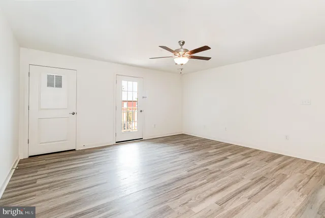 an empty room with wooden floor and windows
