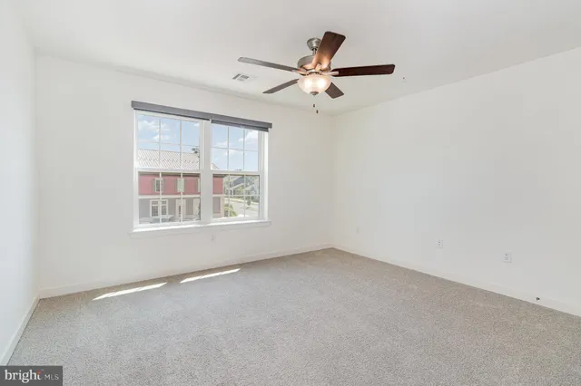 a view of a livingroom with a ceiling fan and window