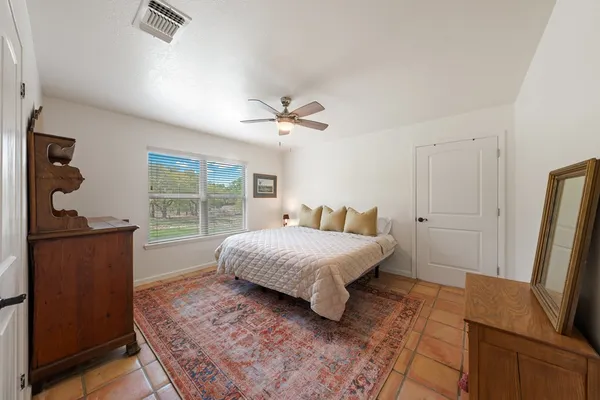 a bedroom with a bed window and a dresser