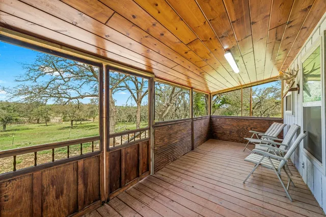 a view of a balcony with chairs and wooden floor