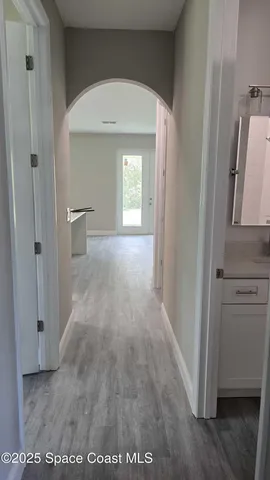 a view of a hallway with wooden floor and closet