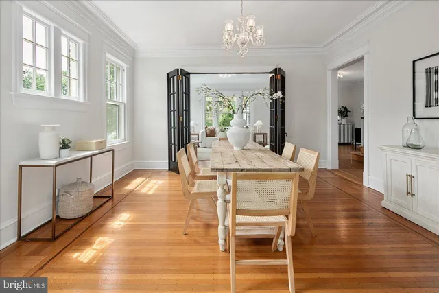 a kitchen with stainless steel appliances granite countertop a stove a sink dishwasher a dining table and chairs with wooden floor