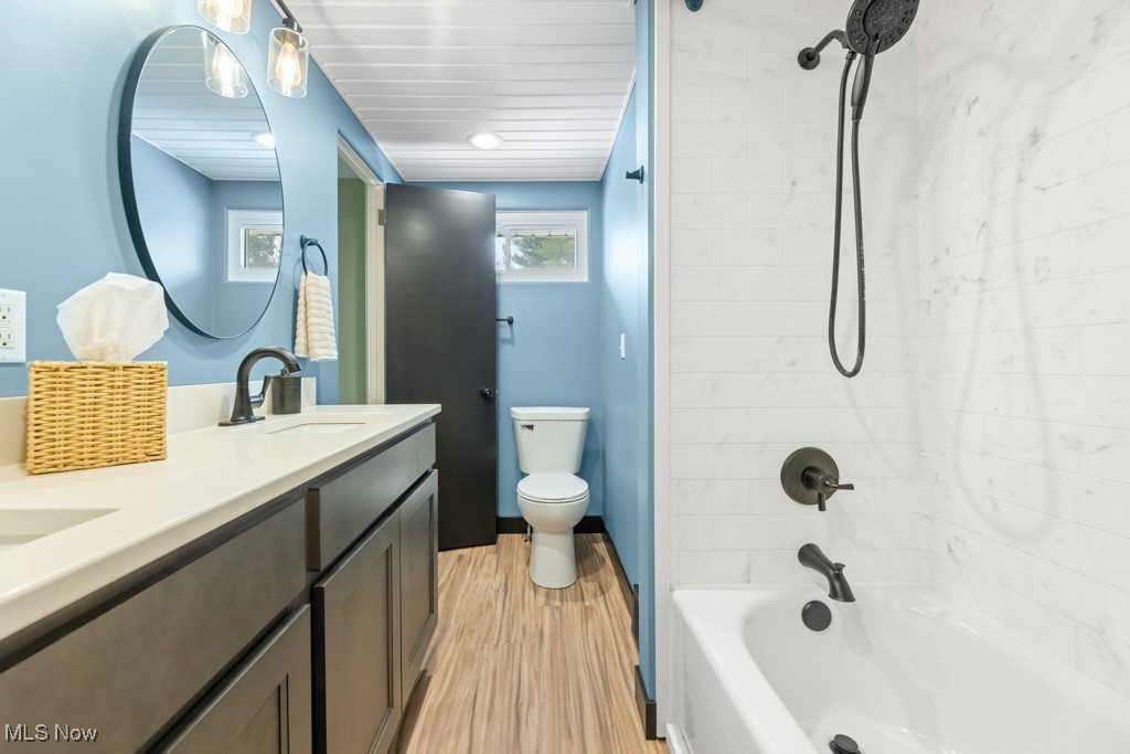 4551 17th Street Northwest Canton, OH 44708 - Photo 24 of 39 Bathroom featuring shower / washtub combination, double vanity, toilet, a sink, and wood finished floors