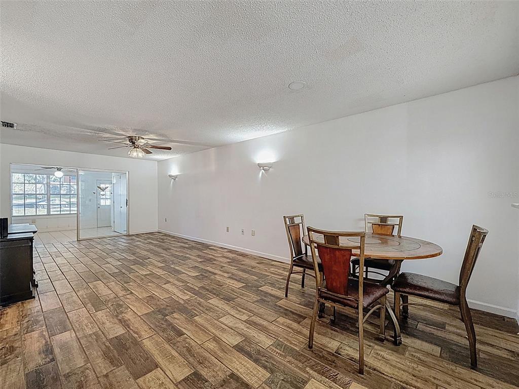 11403 Versailles Lane, Unit E Port Richey, FL 34668 - Photo 21 of 74 a view of a dining room with furniture and wooden floor
