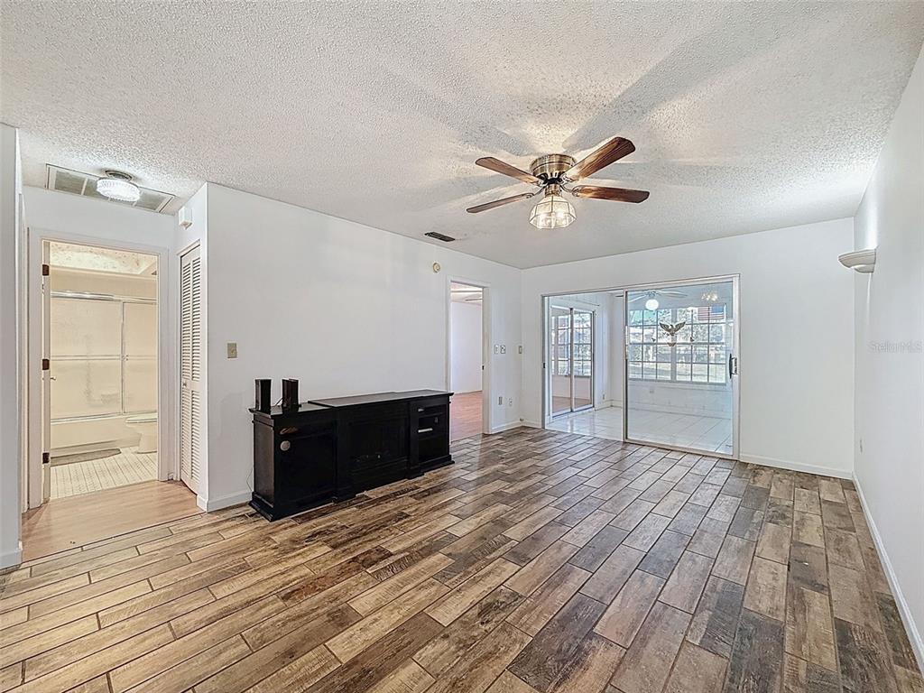 11403 Versailles Lane, Unit E Port Richey, FL 34668 - Photo 22 of 74 a view of empty room with wooden floor and fan