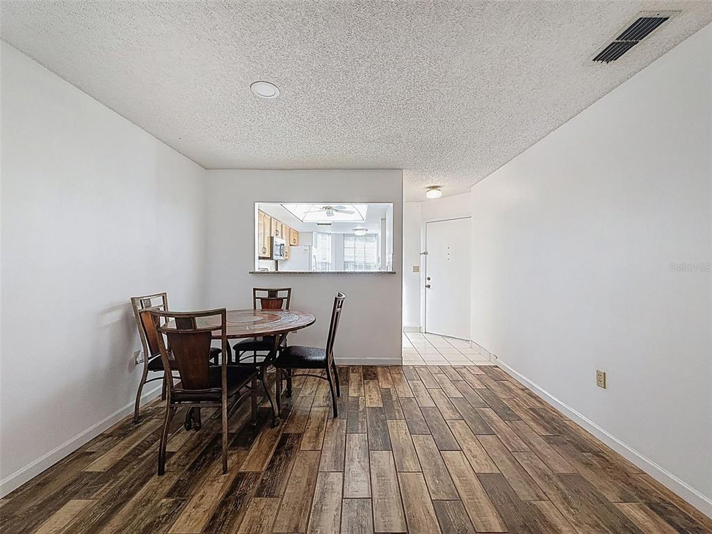 11403 Versailles Lane, Unit E Port Richey, FL 34668 - Photo 29 of 74 a view of a dining room with furniture and wooden floor