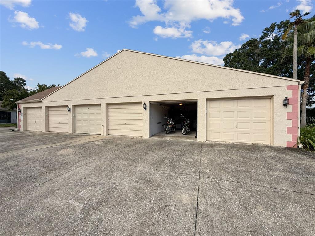 11403 Versailles Lane, Unit E Port Richey, FL 34668 - Photo 33 of 74 a view of a house with a yard and garage
