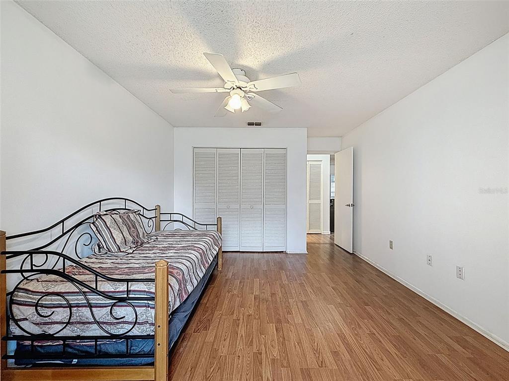 11403 Versailles Lane, Unit E Port Richey, FL 34668 - Photo 35 of 74 a bedroom with a bed and a chandelier