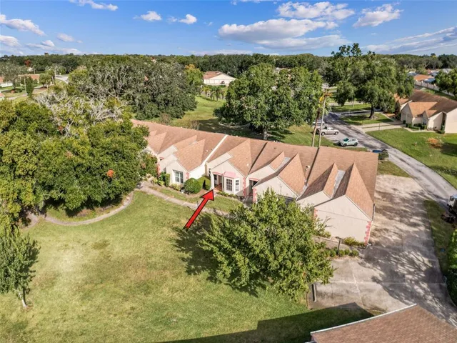 an aerial view of residential houses with outdoor space and trees