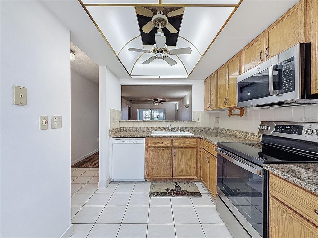 11403 Versailles Lane, Unit E Port Richey, FL 34668 - Photo 6 of 74 a kitchen with stainless steel appliances granite countertop a sink and cabinets