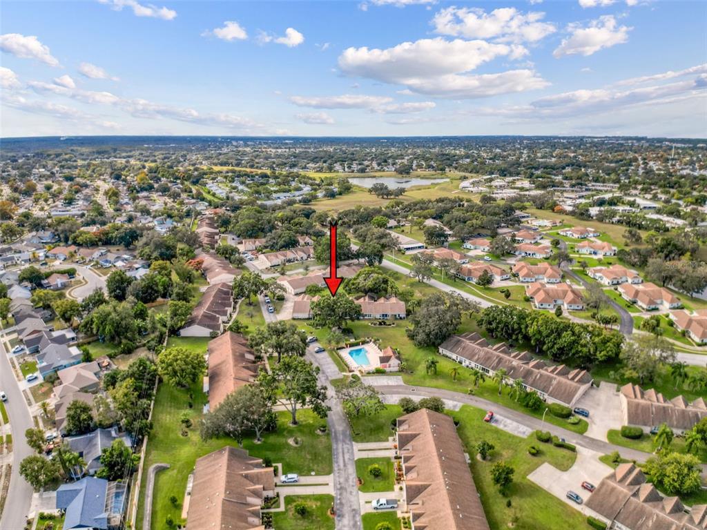 11403 Versailles Lane, Unit E Port Richey, FL 34668 - Photo 68 of 74 an aerial view of residential houses with outdoor space and trees