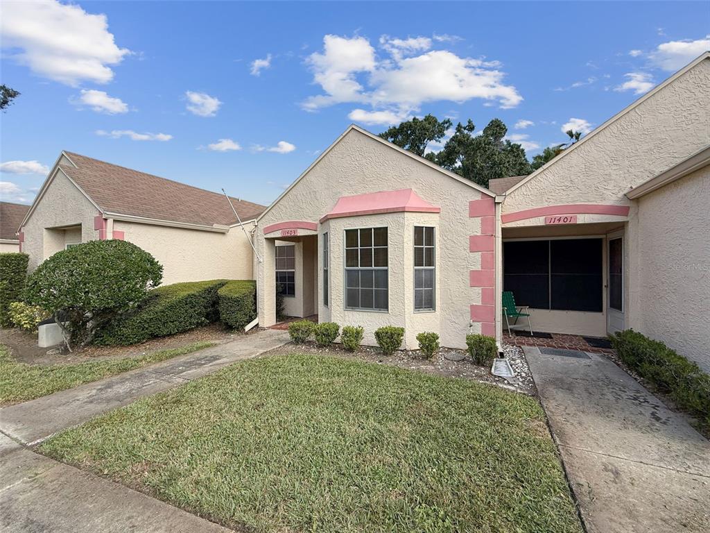 11403 Versailles Lane, Unit E Port Richey, FL 34668 - Photo 72 of 74 a front view of a house with garden