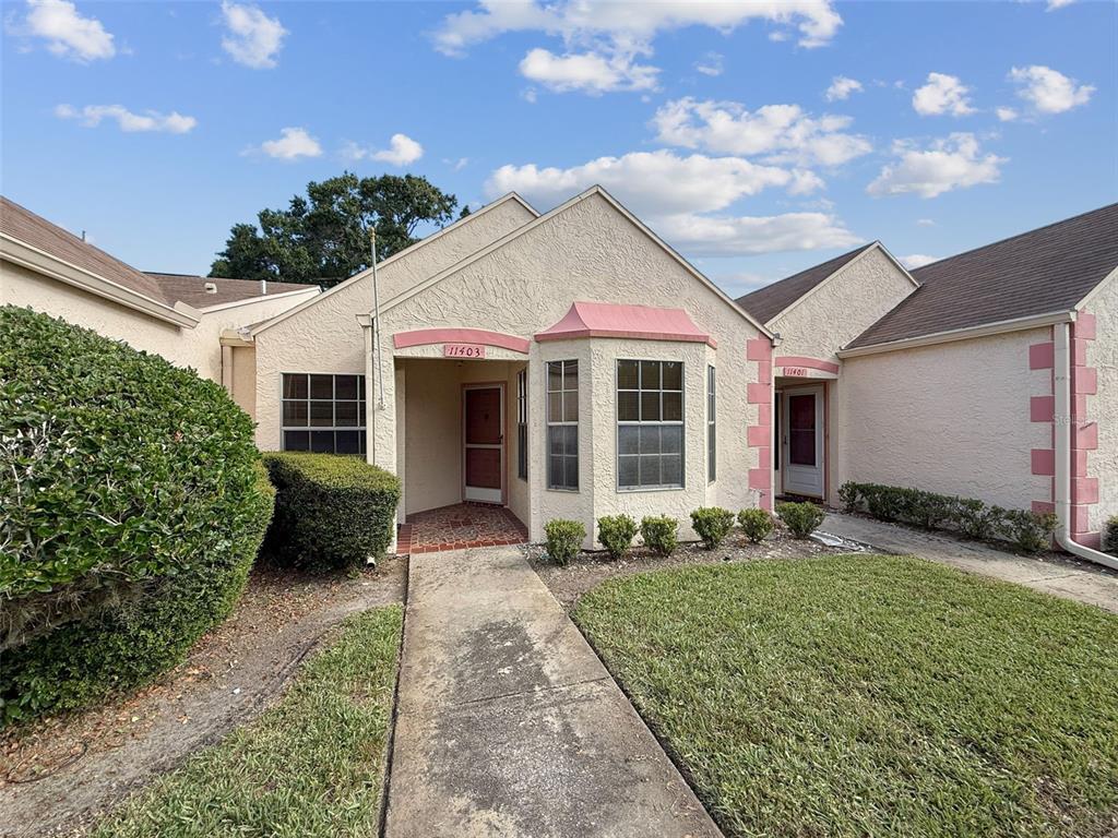 11403 Versailles Lane, Unit E Port Richey, FL 34668 - Photo 74 of 74 a front view of a house with garden
