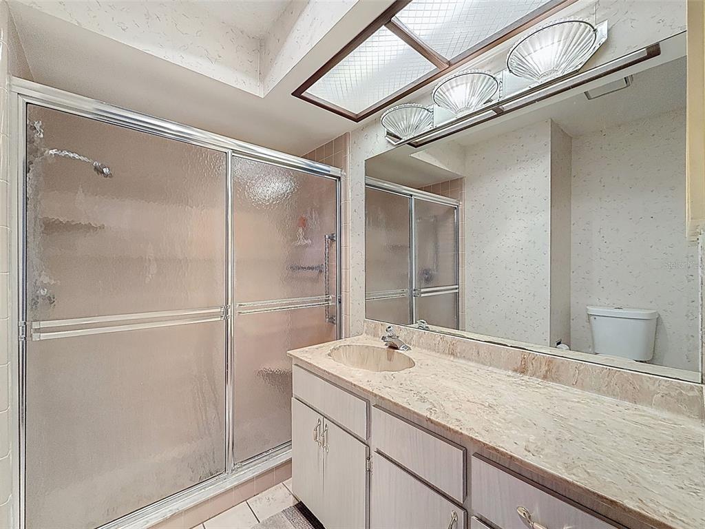 11403 Versailles Lane, Unit E Port Richey, FL 34668 - Photo 10 of 74 a bathroom with a granite countertop sink mirror and vanity