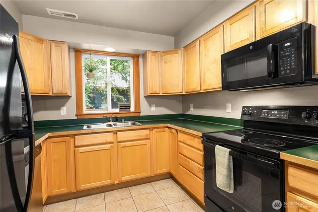 a kitchen with stainless steel appliances a stove sink microwave and cabinets
