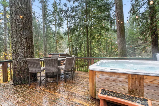 a view of a patio with table and chairs with wooden floor and fence