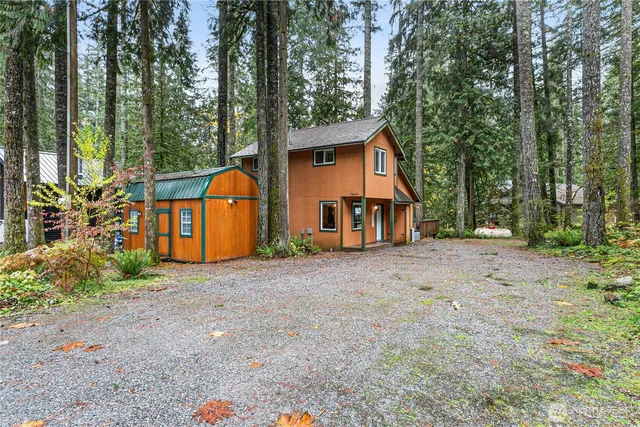 a view of a house with backyard and trees