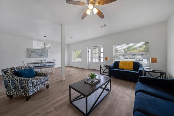 a living room with furniture and a wooden floor
