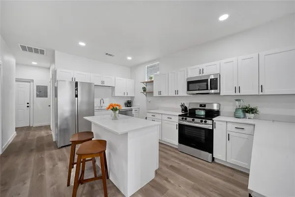 a kitchen with refrigerator a sink and wooden cabinets