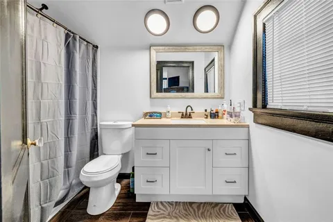 a bathroom with a toilet sink vanity and mirror