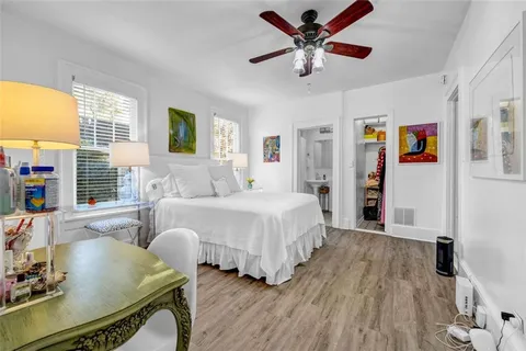a spacious bedroom with a bed a window and a chandelier