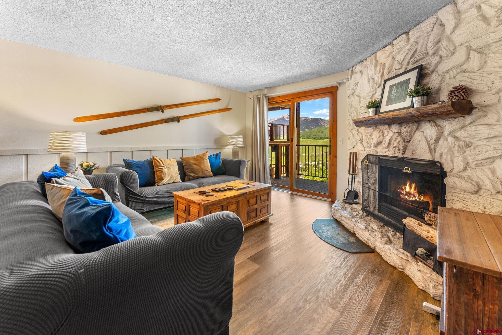 72 Hunter Hill Road, Unit I204 Crested Butte, CO 81225 - Photo 7 of 44 a living room with furniture a fireplace and a flat screen tv