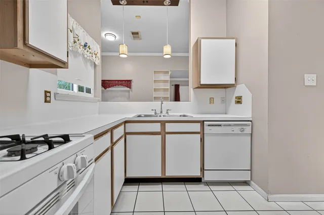a kitchen with granite countertop a sink and white cabinets