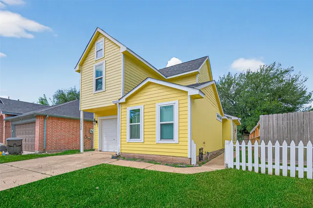 a view of a house with a yard and wooden fence