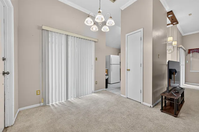 a view of a hallway with chandelier and a livingroom