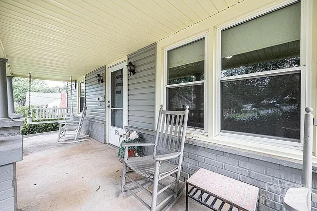 a porch with a table and chairs