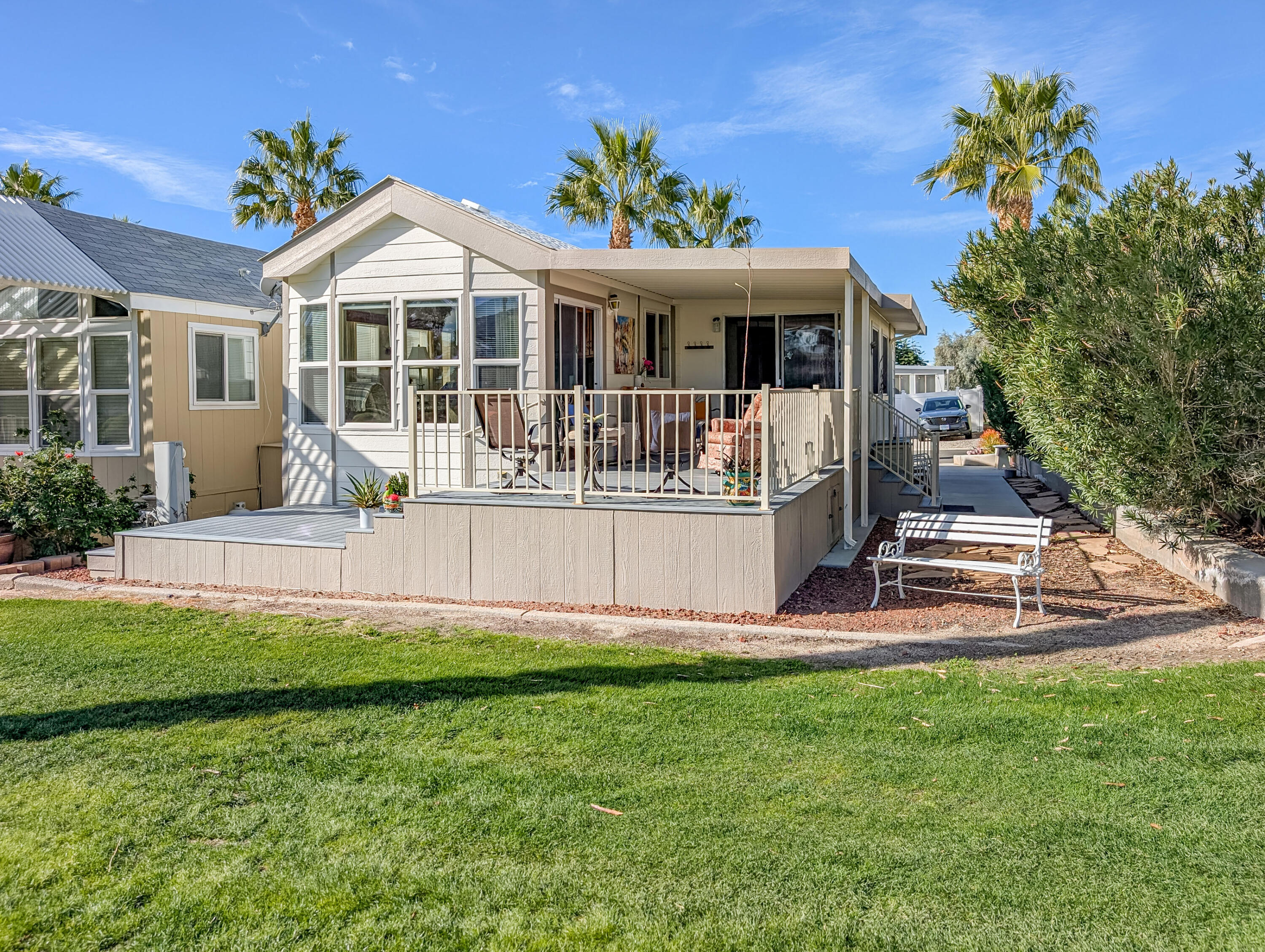 70200 Dillon Road, Unit 590 Desert Hot Springs, CA 92241 - Photo 18 of 42 a front view of a house with a yard table and chairs
