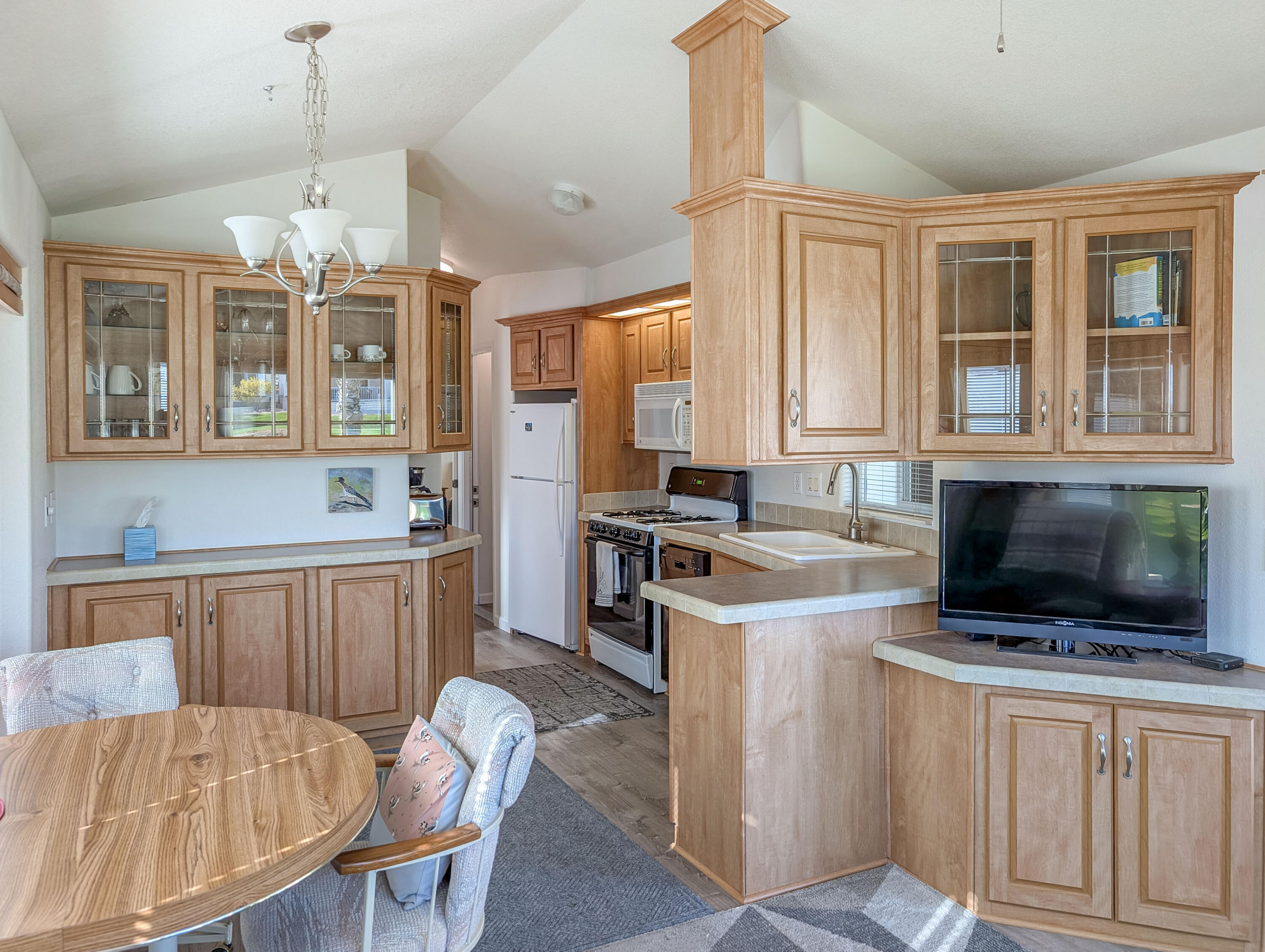 70200 Dillon Road, Unit 590 Desert Hot Springs, CA 92241 - Photo 23 of 42 a kitchen that has a stove a microwave and a dining table