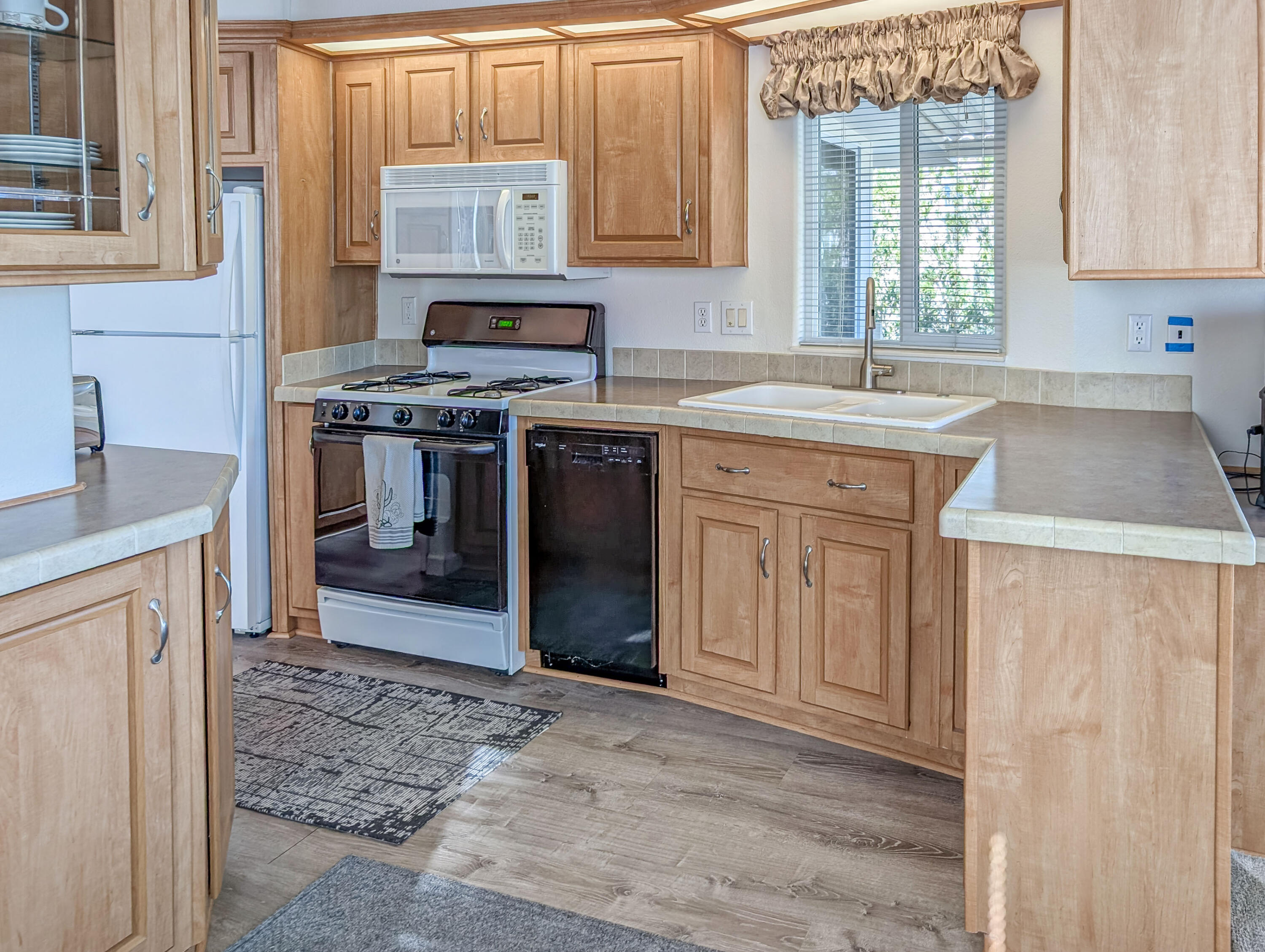 70200 Dillon Road, Unit 590 Desert Hot Springs, CA 92241 - Photo 25 of 42 a kitchen with stainless steel appliances granite countertop a sink stove and cabinets