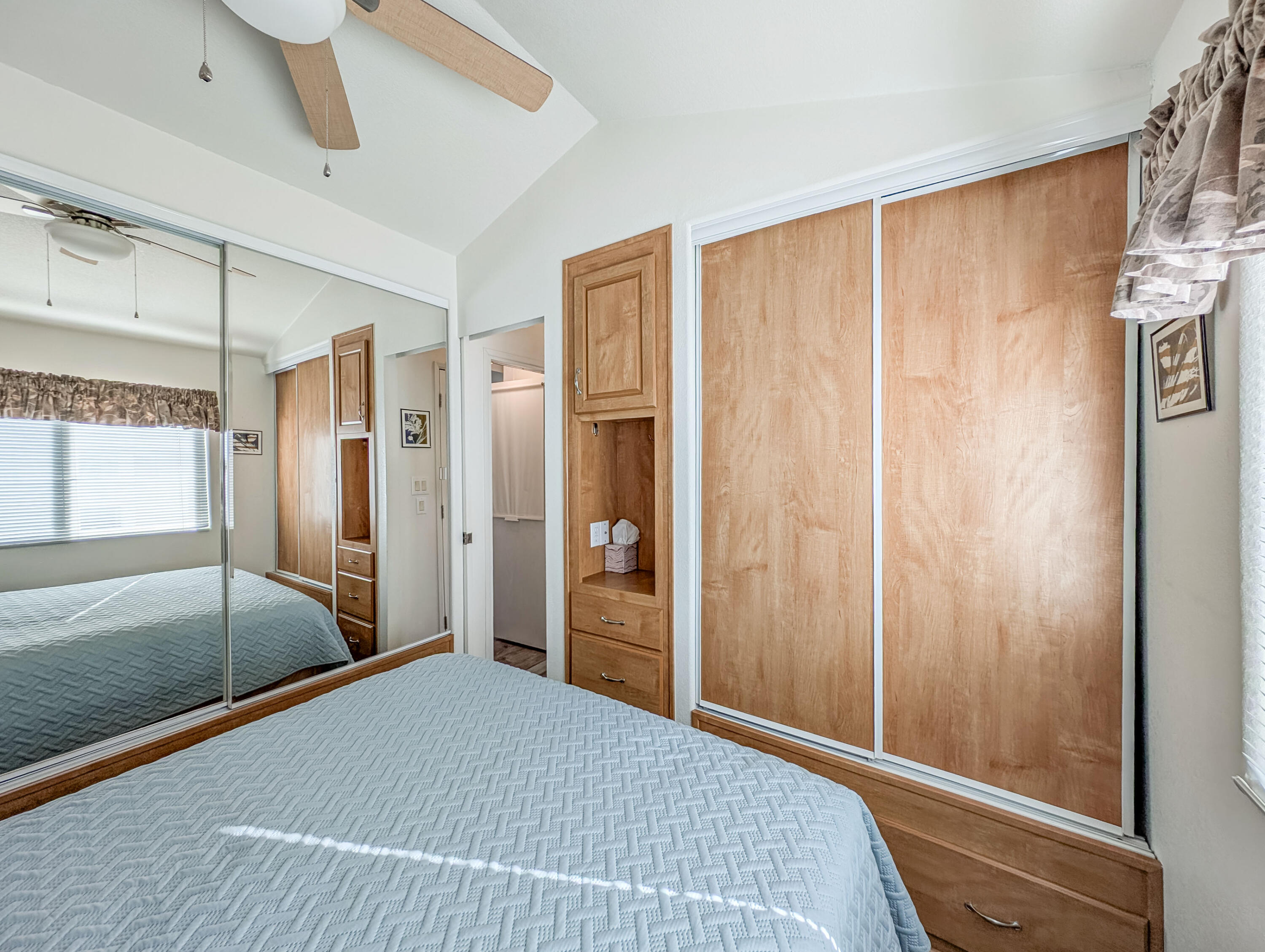 70200 Dillon Road, Unit 590 Desert Hot Springs, CA 92241 - Photo 35 of 42 a bedroom with a bed and a chandelier fan