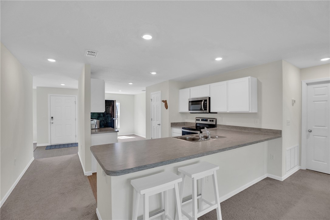 938 Clearmont Street Sebastian, FL 32958 - Photo 13 of 36 a kitchen with a sink a counter top space cabinets and stainless steel appliances