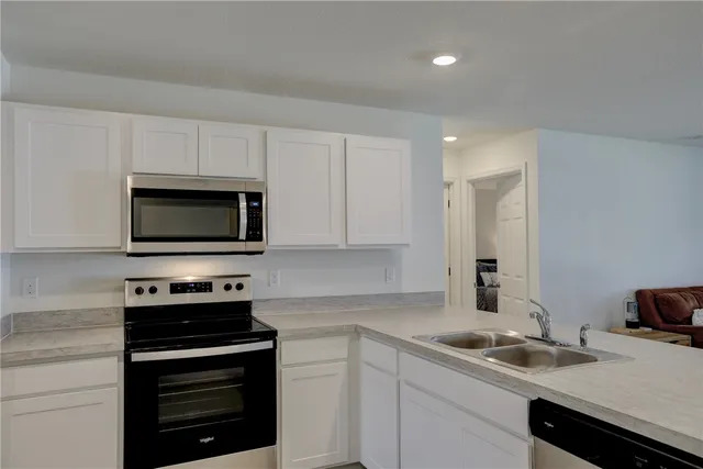 a kitchen with a sink stove and microwave