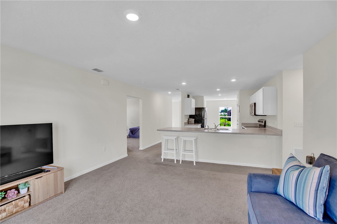 938 Clearmont Street Sebastian, FL 32958 - Photo 16 of 36 a living room with furniture and a flat screen tv