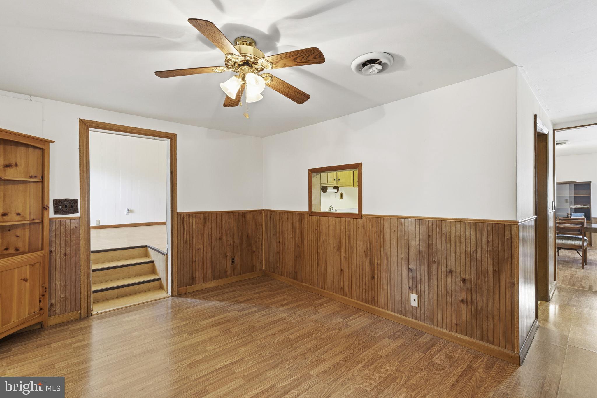 2411 Poplar Road Baltimore, MD 21221 - Photo 9 of 36 a view of an empty room with wooden floor and a ceiling fan