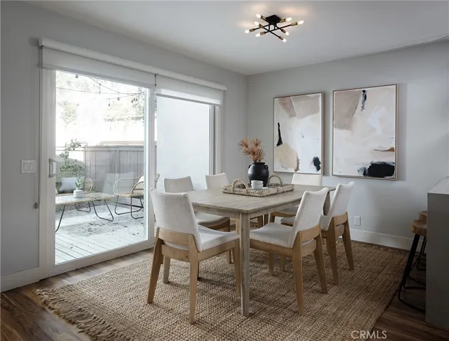 a dining room with wooden floor a chandelier a wooden table and chairs